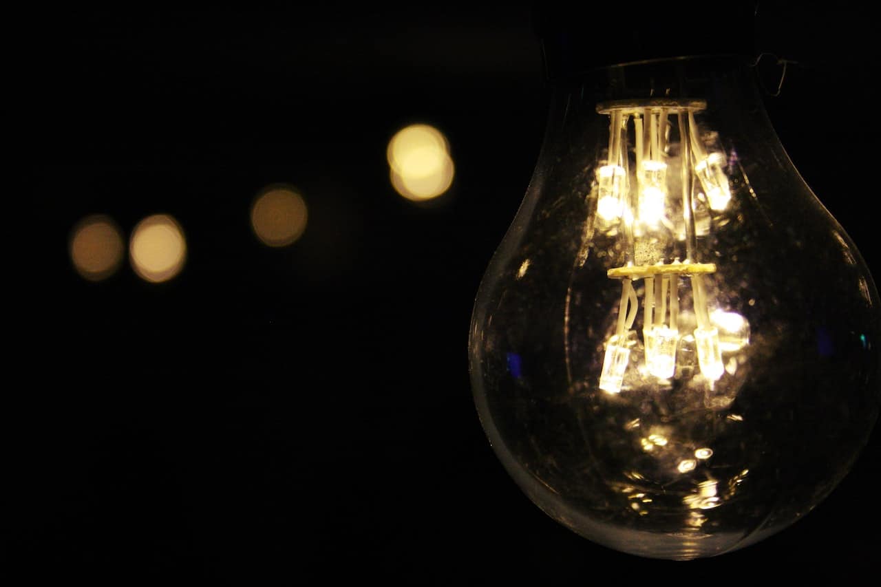 A light bulb is lit up in the dark.