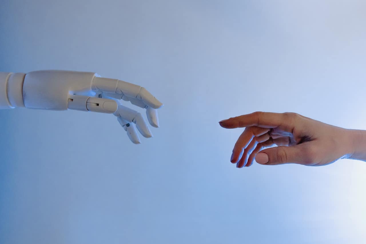 A robotic hand reaching out to a human hand.