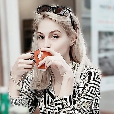 A young woman drinking coffee at a cafe.